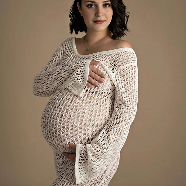 Witte gebreide zwangerschaps midi jurk met ronde hals, ideaal voor fotoshoot.