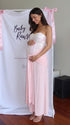 Roze babyshower zwangerschaps jurk met glanzende pailletten, geplooide details en knoopdetail.