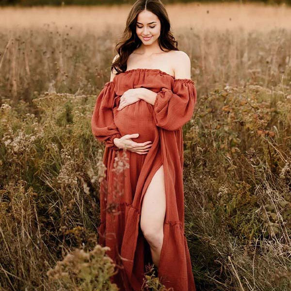 Oranje boho zwangerschaps maxi jurk met off shoulder hals, ruches en zijsplit voor fotoshoot.