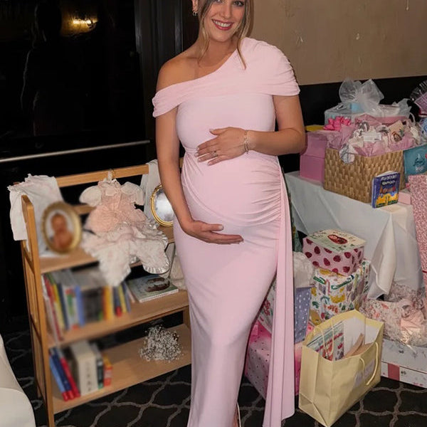 Roze zwangerschaps maxi jurk met off-shoulder en gedrapeerde details, ideaal voor een babyshower.