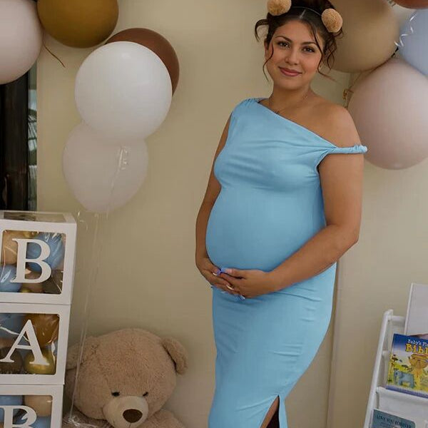 Blauwe zwangerschaps maxi jurk met one-shoulder, zijsplit en bodycon pasvorm, ideaal voor een babyshower.