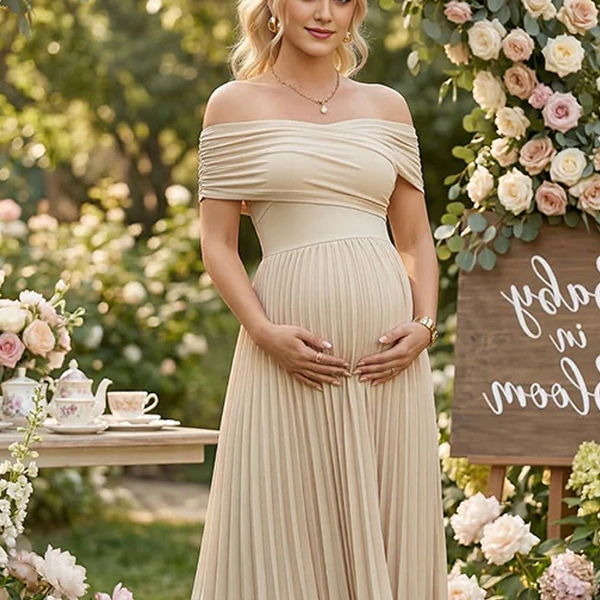 Abrikooskleurige zwangerschaps maxi jurk met off-shoulder en geplooide buste, ideaal voor fotoshoots.