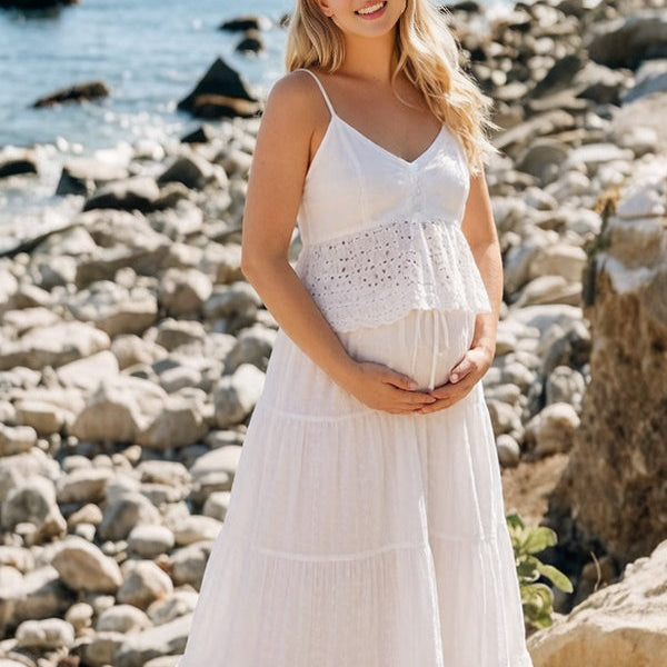 Vooraanzicht van een witte zwangerschapsfotoshoot jurk op het strand