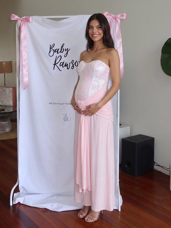 Roze zwangerschaps maxi jurk met pailletten, bandeau hals, geplooid knoopdetail en bodycon pasvorm voor babyshower.