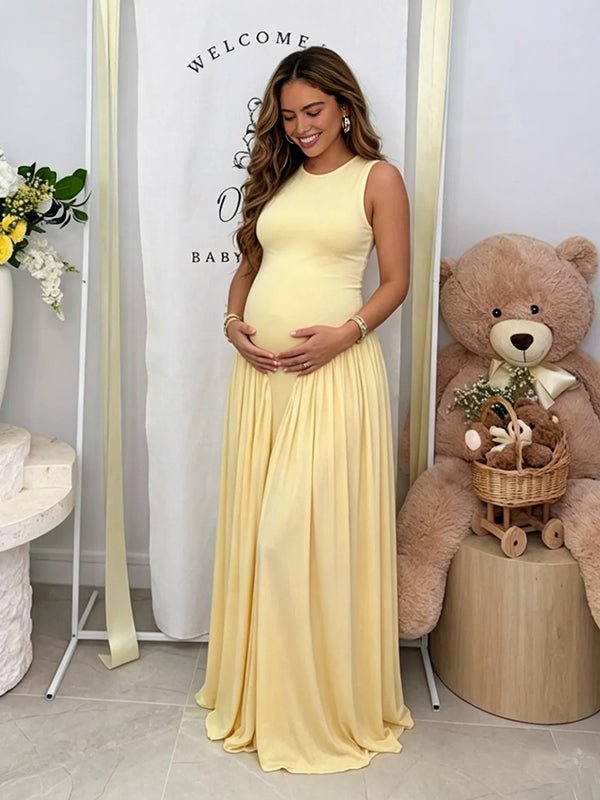 Gele zwangerschaps maxi jurk met gedrapeerde details en elegante bodycon pasvorm.