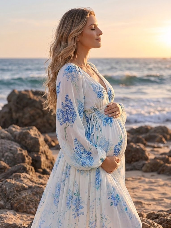 Blauwe zwangerschaps maxi jurk met bloemenpatroon, ruches en luchtige uitstraling voor fotoshoot.
