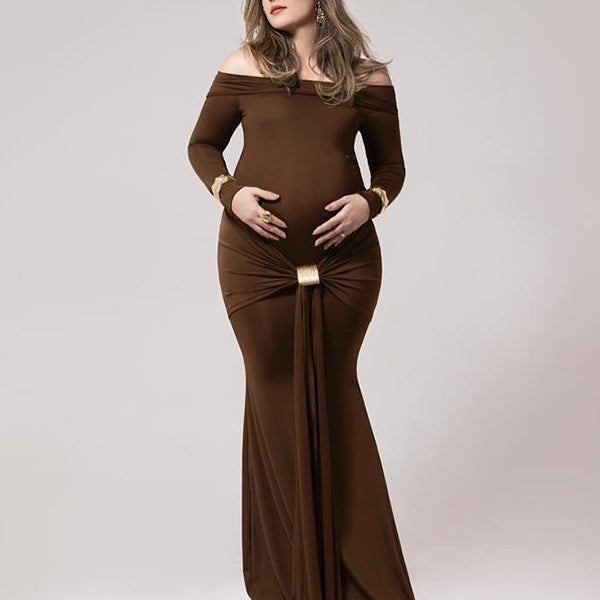 Koffiekleurige zwangerschaps maxi jurk met off-shoulder, knoopdetail en geplooide bodycon pasvorm, ideaal voor fotoshoot.