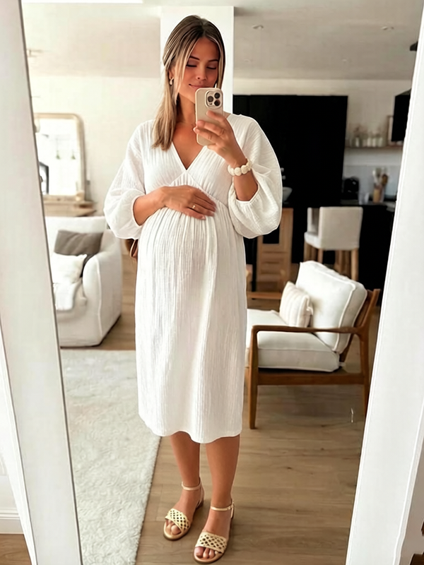 Witte zwangerschaps maxi jurk met gedrapeerd detail.
