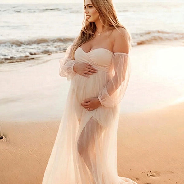 Vooraanzicht van een beige zwangerschapsfotoshoot jurk op het strand