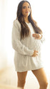 Witte oversized zwangerschaps truijurk met warm grofgebreid kabelpatroon.