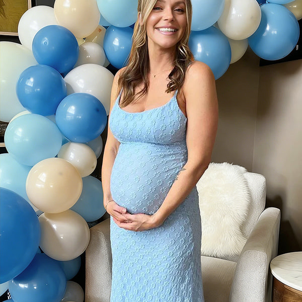 Blauwe zwangerschaps maxi jurk met bloemenprint, spaghettibandjes en bodycon pasvorm, ideaal voor babyshower.
