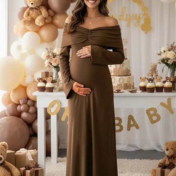Bruine zwangerschaps maxi cocktailjurk met off-shoulder design, gekreukte stof en trapeze pasvorm, ideaal voor feestelijke gelegenheden.