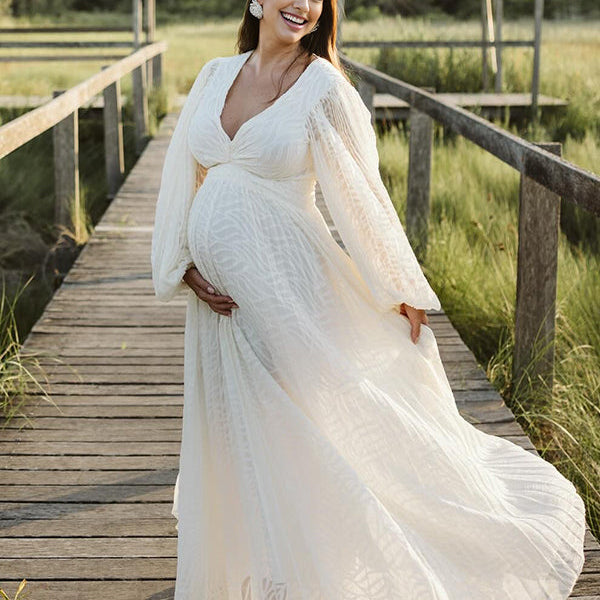 Elegante zwangerschaps maxi jurk met open rug en geplooide details, ideaal voor een fotoshoot.