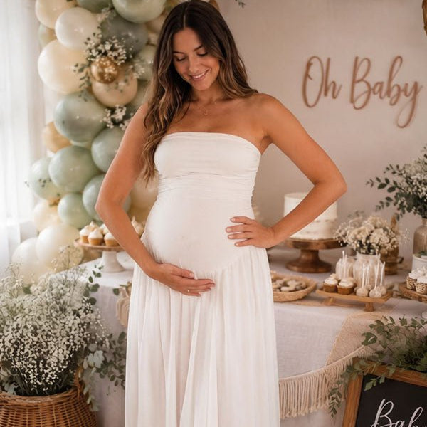 Witte zwangerschaps maxi jurk met bandeau halslijn, geplooide details en zijsplit, ideaal voor fotoshoots.