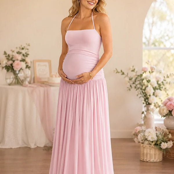 Roze zwangerschaps maxi jurk met halternek, rugloos design, vetersluiting en gerimpelde zijkanten voor party.