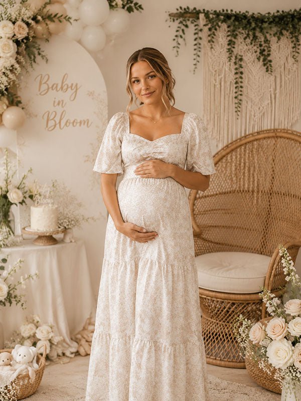 Beige bloemenprint zwangerschaps maxi jurk met gesmokt design en flowy A-lijn pasvorm voor fotoshoot.