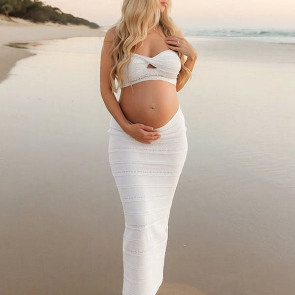 Vooraanzicht van een witte zwangerschapsfotoshoot jurk op het strand
