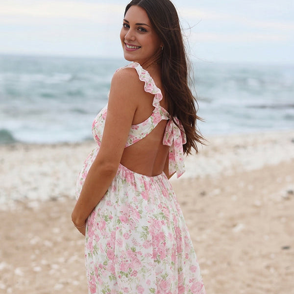Witte boho zwangerschaps maxi jurk met bloemenprint en ruches.