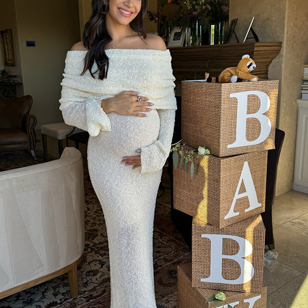 Witte zwangerschaps maxi jurk met off-shoulder gebreid design en bodycon pasvorm, ideaal voor babyshower.