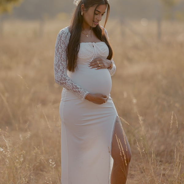Witte zwangerschaps maxi jurk met kant, vierkante hals en zijsplit, ideaal voor fotoshoot.