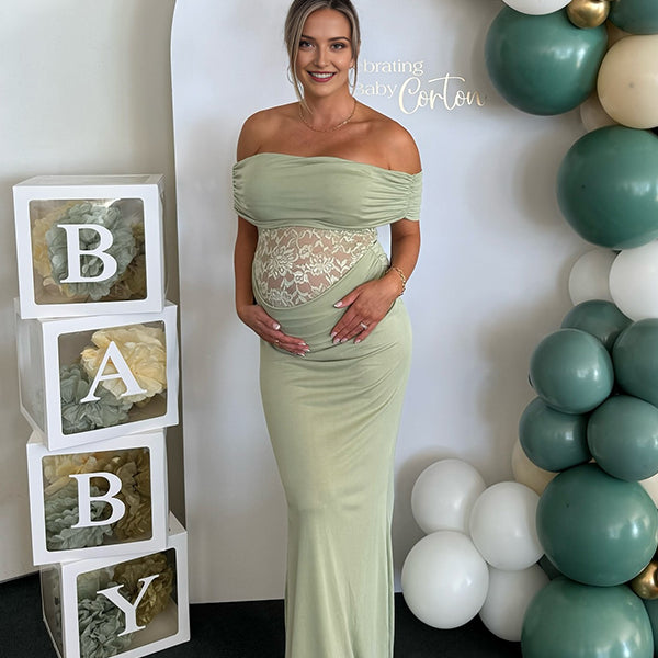 Groene zwangerschaps maxi jurk met off-shoulder en kanten details, ideaal voor babyshower.