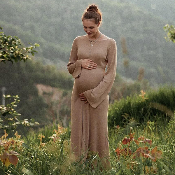 Kakikleurige zwangerschaps maxi jurk met open rug en flare mouwen, ideaal voor een fotoshoot.