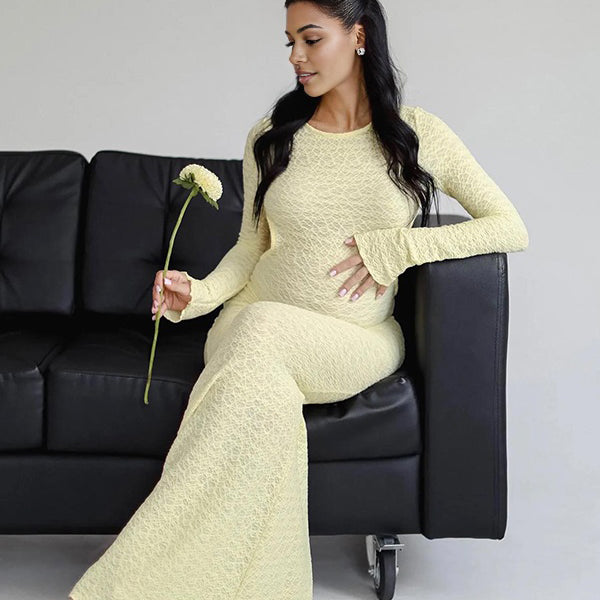 Gele zwangerschaps maxi jurk met open rug en kanten details, ideaal voor een fotoshoot.