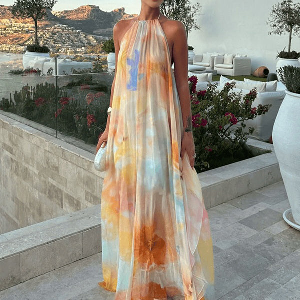 Oranje zwangerschaps maxi jurk met tie-dye, bloemenprint en open rug, ideaal voor een vakantie.