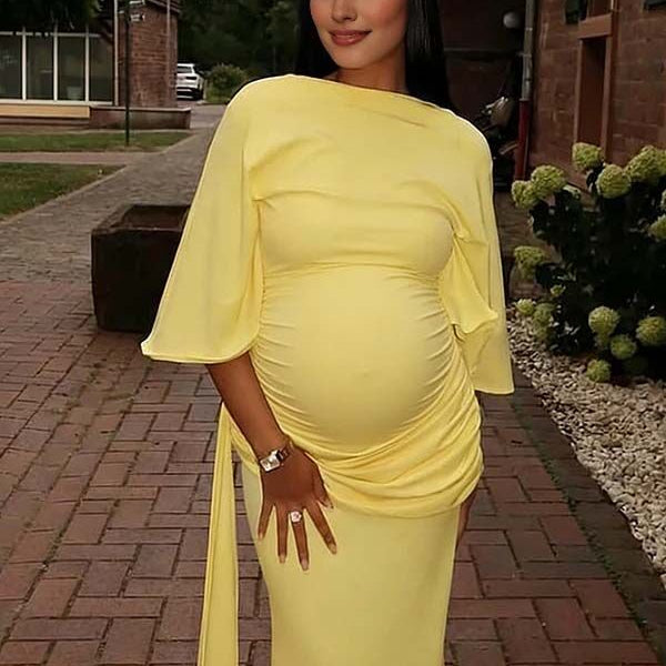 Gele zwangerschaps maxi jurk met open rug en zijsplit, ideaal voor een babyshower.