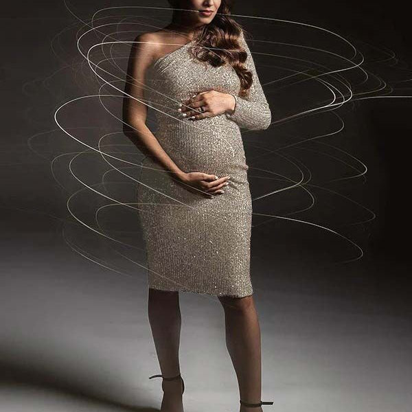 Abrikooskleurige zwangerschaps mini jurk met pailletten en one-shoulder, ideaal voor fotoshoot.