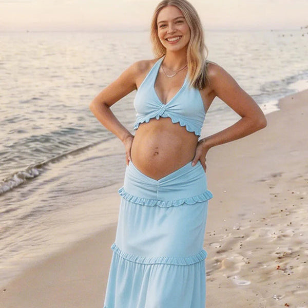 Vooraanzicht van een blauwe zwangerschapsfotoshoot jurk op het strand