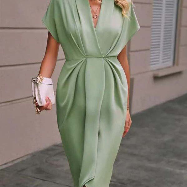 Groene zwangerschaps midi jurk met plooien, zijsplit en asymmetrische zoom, ideaal voor werk.
