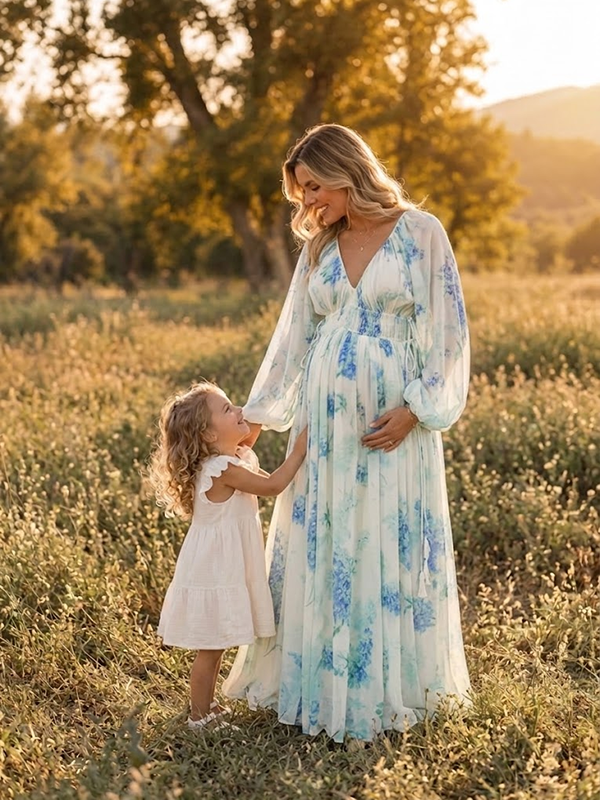 Blauwe zwangerschapsjurk met bloemenprint en vrouwelijke ruches voor een elegante look voor fotoshoot.